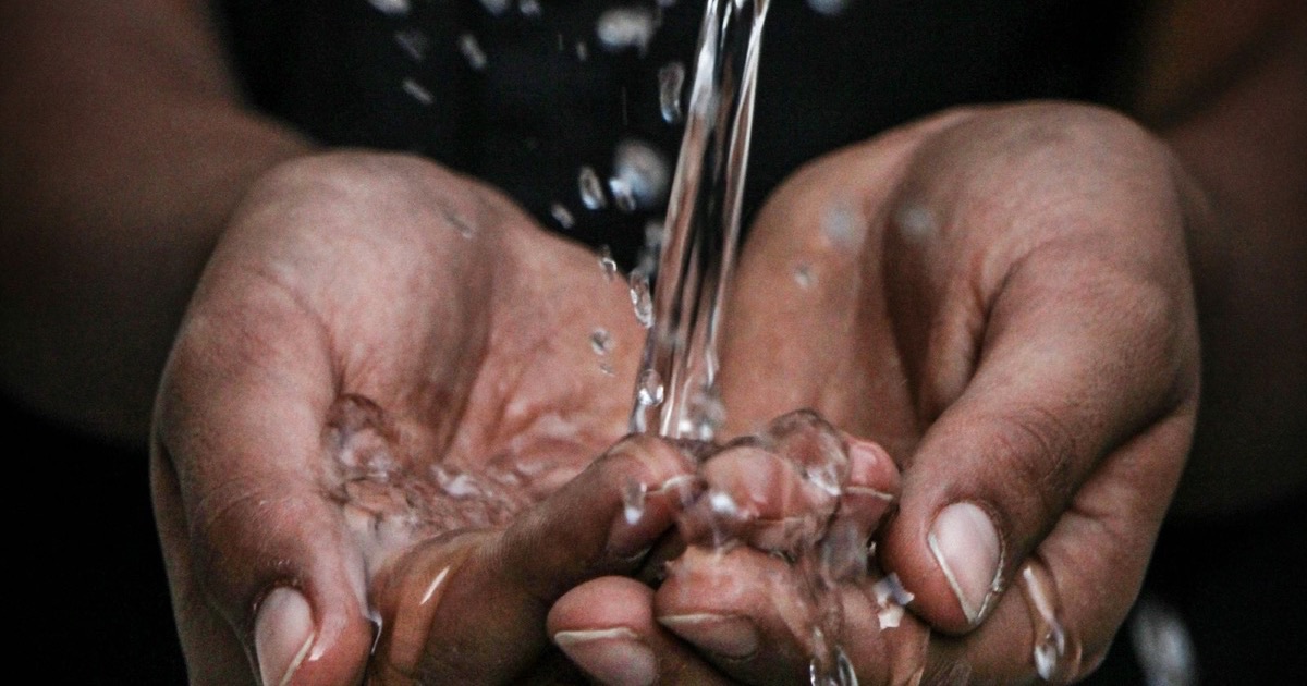 Hände fangen sauberes, fließendes Trinkwasser auf, Sinnbild für die Daseinsvorsorge und den Personalbedarf der Wasserversorgung